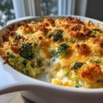 Close-up of a creamy, baked broccoli casserole topped with golden brown cheese and crispy breadcrumbs.