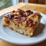 A close-up of a moist slice of Apple Cinnamon French Toast with a caramelized, browned top.
