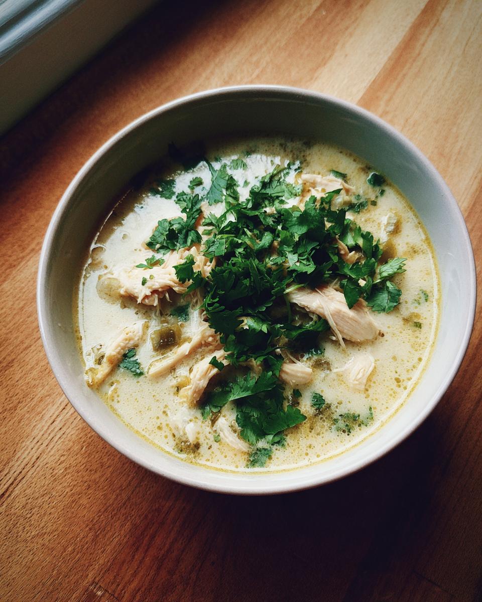 Overhead view of a bowl of creamy chicken poblano soup recipe topped generously with fresh cilantro.