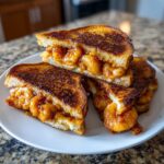 Close-up of perfectly grilled shrimp toast, cut in half, revealing a generous, saucy shrimp filling.