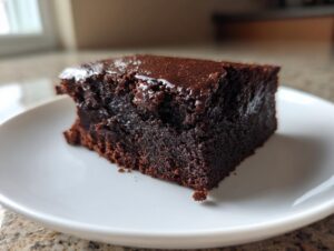 Close-up of a rich, fudgy slice of sweet potato brownies with a glossy top.