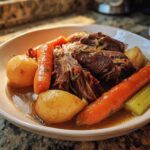 Shredded pot roast served with carrots, potatoes, and celery, ideal for Sunday dinner ideas.