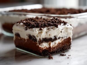 A rich, layered slice of amazing dirt cake featuring chocolate pudding, cream, and cookie crumbs.
