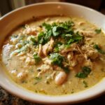 Close-up of a bowl of creamy white chicken chili recipe topped generously with fresh cilantro.