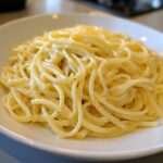 Close-up shot of spaghetti coated in a rich, creamy lemon sauce, showcasing the creamy lemon pasta texture.
