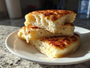 Close-up of three stacked pieces of sourdough pancakes showing their airy, fluffy interior and golden-brown cooked exterior.