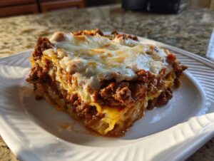 A generous slice of lazy lasagna featuring rich meat sauce and a bubbly, melted cheese topping on a white plate.