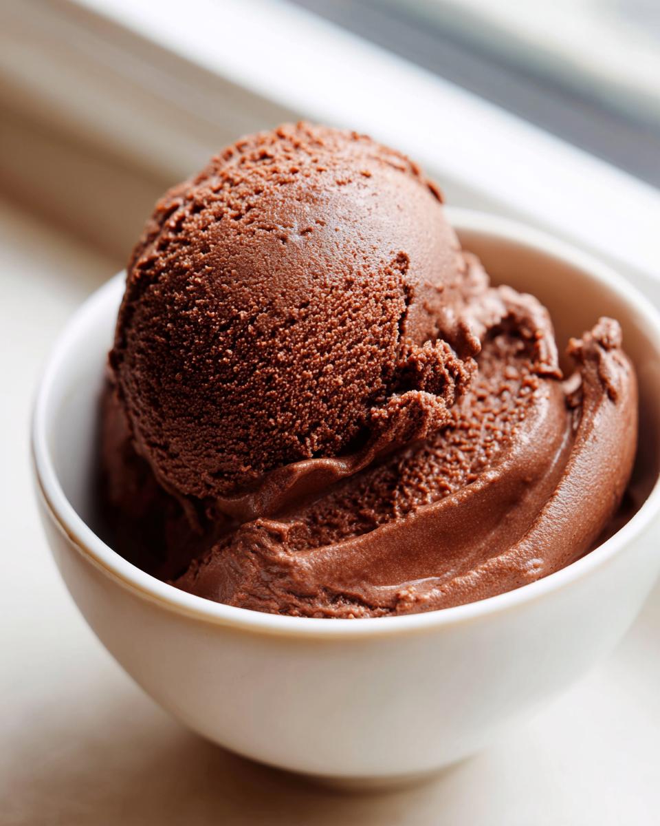 A perfect scoop of rich, dark homemade chocolate pudding served in a small white bowl.