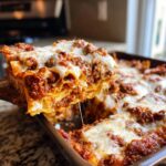 A generous slice of cheesy, meaty lazy lasagna being lifted from a baking dish.