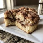 Two soft coffee cake cookies, cut in half, showing cinnamon swirl and crumbly streusel topping.