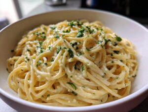 Close-up of creamy spaghetti coated in a rich garlic parmesan sauce, topped with fresh parsley.