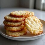A stack of golden brown, slightly textured 3-ingredient butter cookies resting on a small white plate.