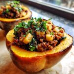 A close-up of a roasted acorn squash half filled with a savory stuffing featuring quinoa, diced apples, and kale, making a perfect stuffed acorn squash.