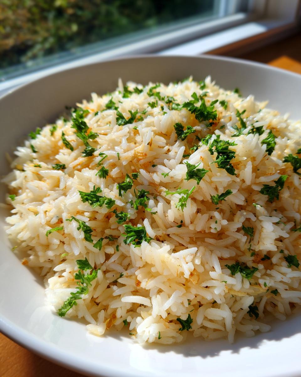 A close-up of fluffy, perfectly cooked rice pilaf garnished generously with chopped fresh parsley.