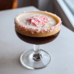 A rich peppermint espresso martini topped with foam and crushed candy canes.