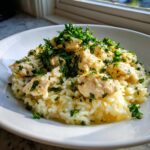 Close-up of chicken scampi with garlic parmesan rice, topped generously with fresh chopped parsley.