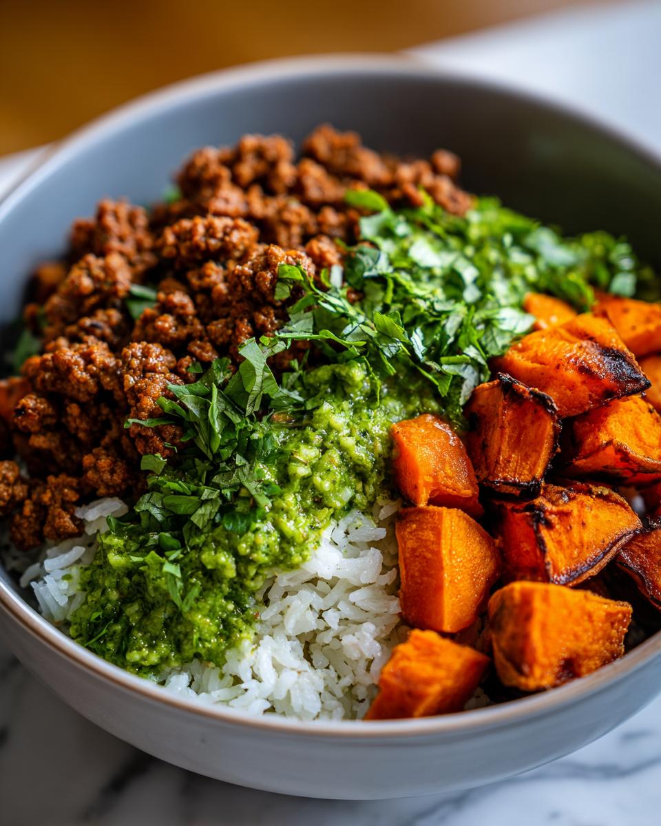 Close-up of a ground turkey sweet potato taco bowl with rice, green sauce, and fresh cilantro.