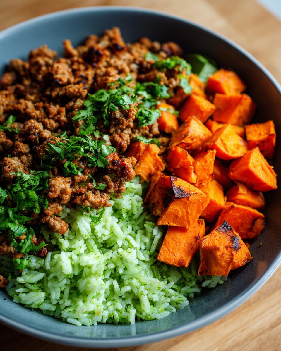 Close-up of a ground turkey sweet potato taco bowl with green rice and cilantro garnish.