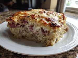 A generous slice of homemade Reuben bake with a golden, bubbly cheese crust and visible corned beef pieces.