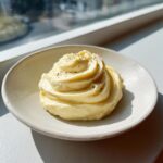 A dollop of creamy lemon garlic aioli recipe, piped into a swirl and topped with black pepper.