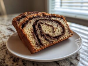 Two thick slices of sourdough cinnamon swirl bread showing a beautiful dark cinnamon spiral, served on a white plate.