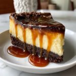 A rich slice of chocoflan dessert layered with dark chocolate crust, creamy filling, and dripping with caramel sauce.