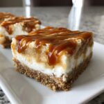 A close-up of a decadent caramel apple cheesecake bars slice topped with thick caramel sauce drizzle.