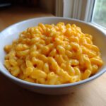 Close-up of a white bowl filled with creamy, bright orange easy homemade mac and cheese.