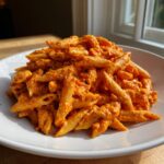 A generous serving of creamy tomato pasta with boursin cheese, featuring penne pasta coated in a rich orange sauce.