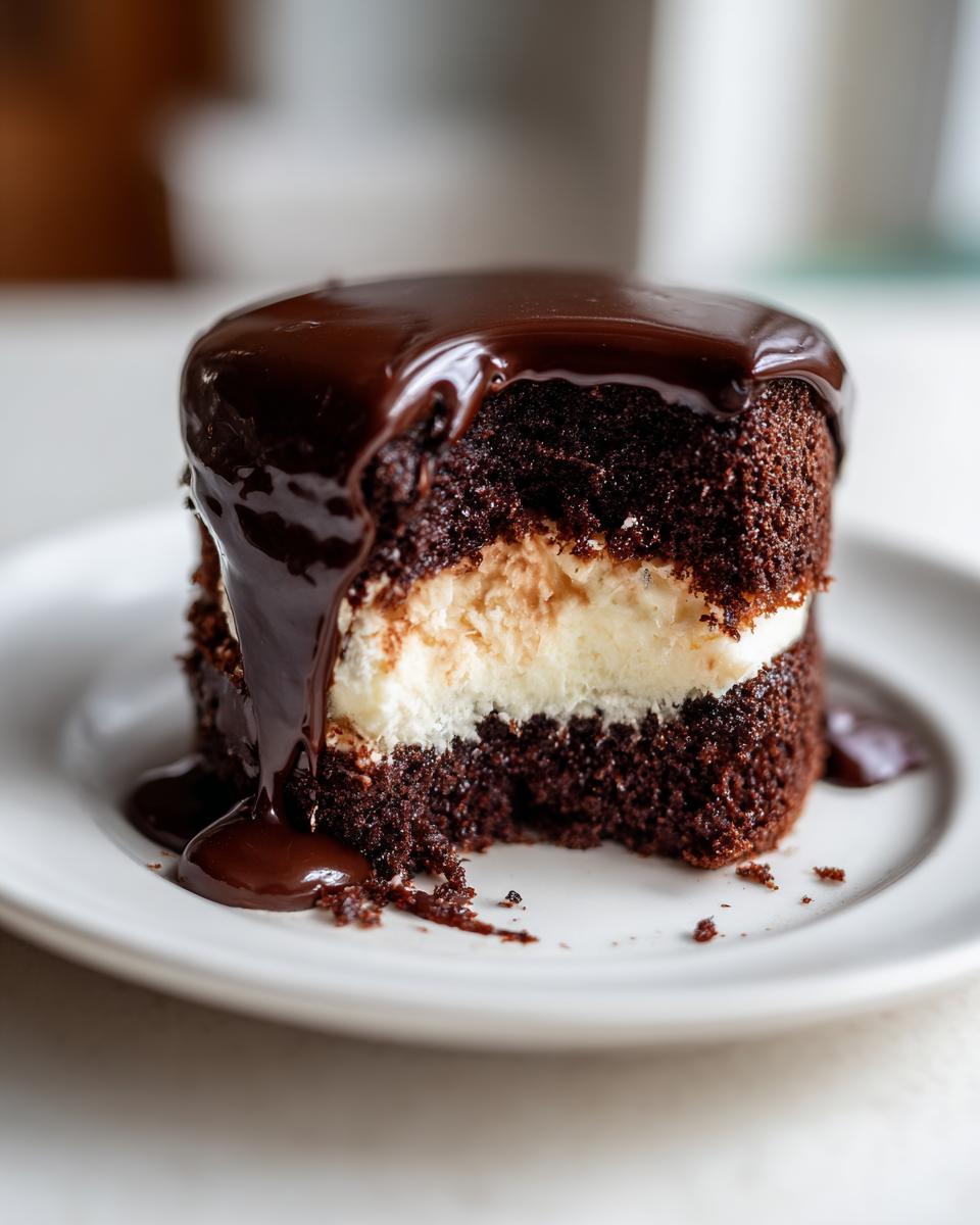 Close-up of a rich, dark chocolate ding dong cake slice with creamy filling and dripping chocolate ganache.