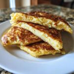 A stack of four golden brown, pan-fried slices of mashed potato pancakes on a white plate.