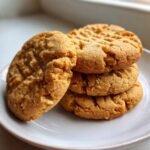 Close-up of a small stack of four softest peanut butter cookies showing classic fork marks.